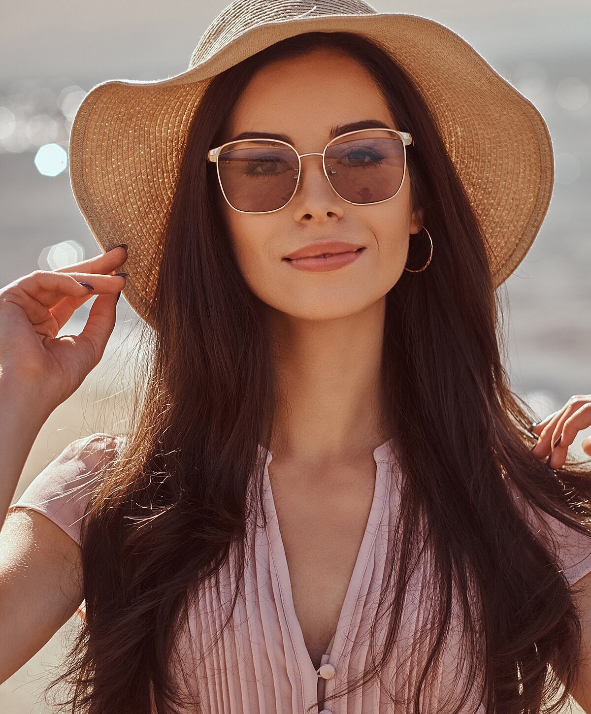 Woman with wet hair sitting on the beach.