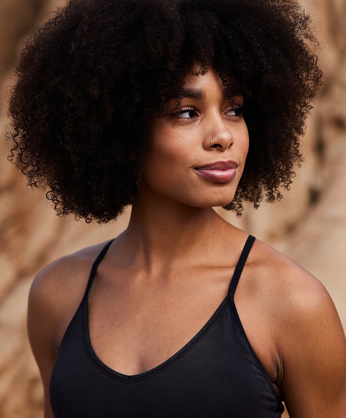 Woman relaxing by a pool, serene expression.
