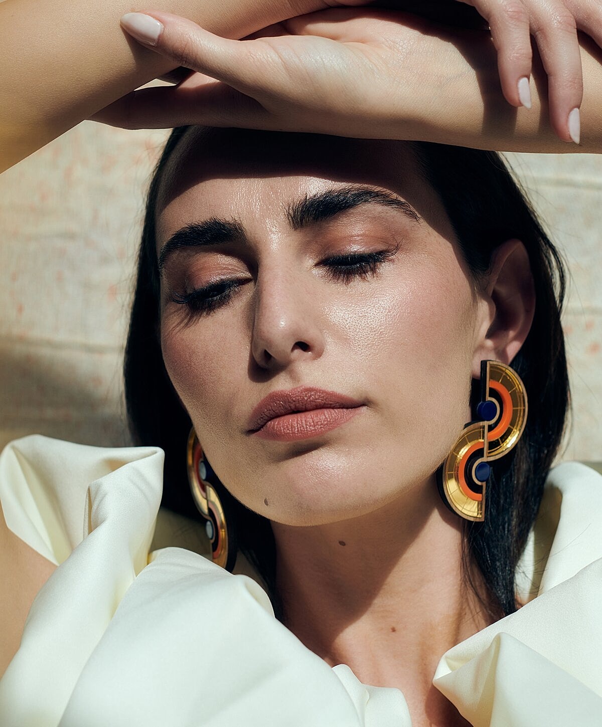 Woman relaxing by a pool, serene expression.
