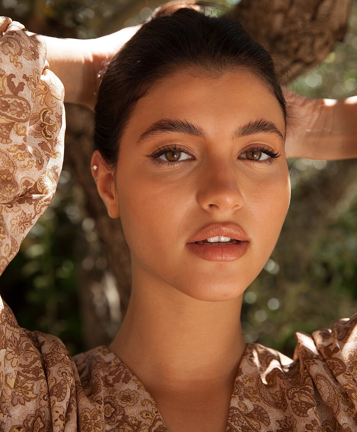 Woman relaxing by a pool, serene expression.