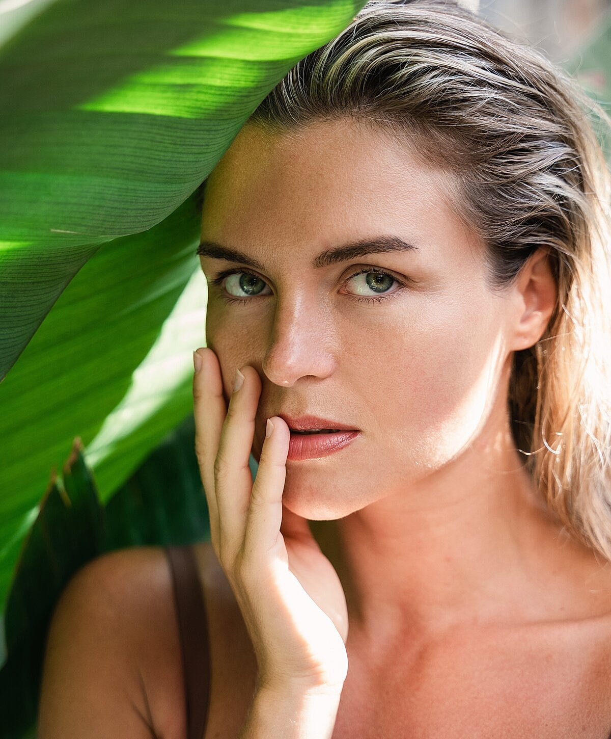Woman relaxing by a pool, serene expression.